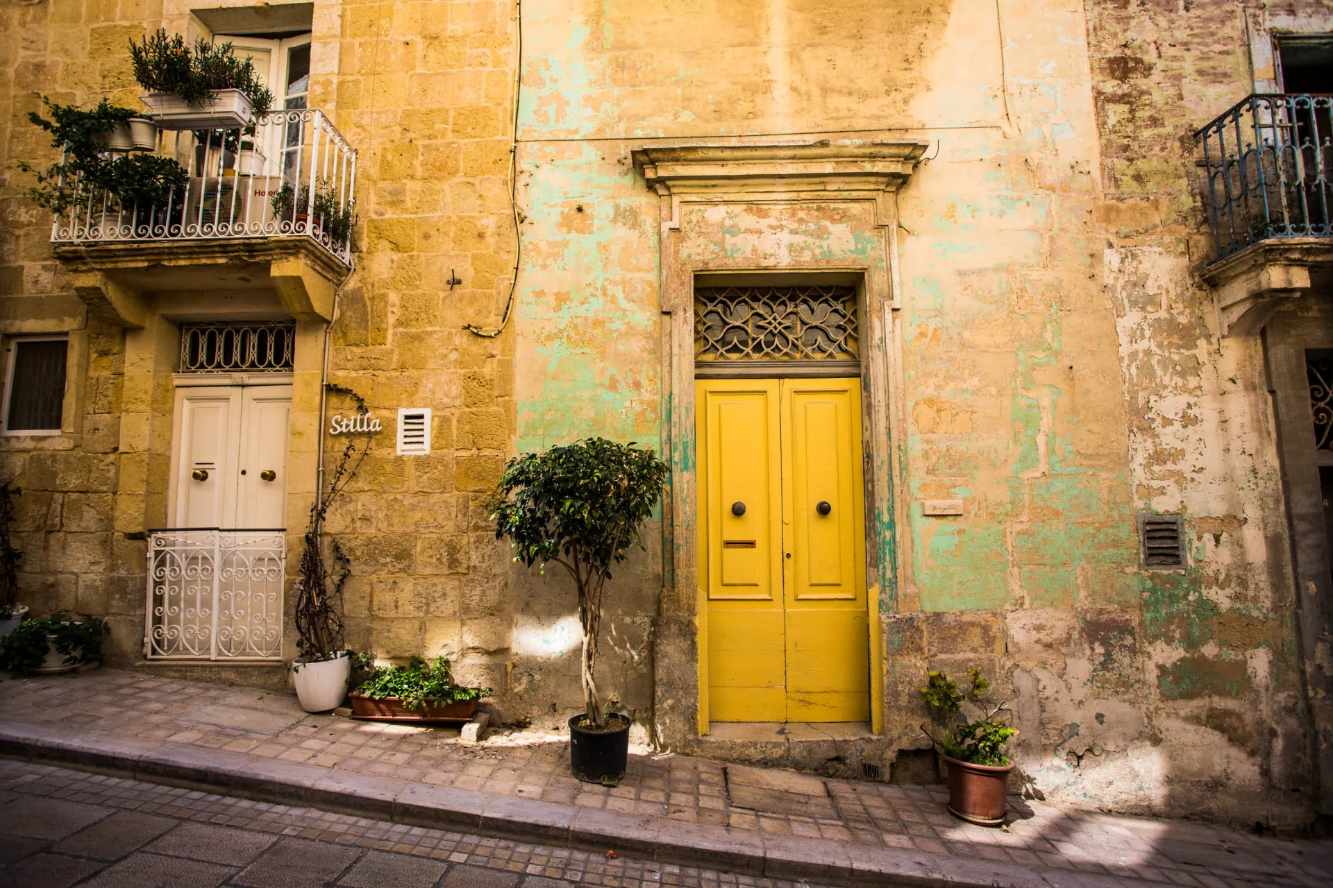 Viehättävä julkisivu, jossa on keltainen ovi Vittoriosassa – esimerkki Maltan värikkäästä kaupunkiympäristöstä