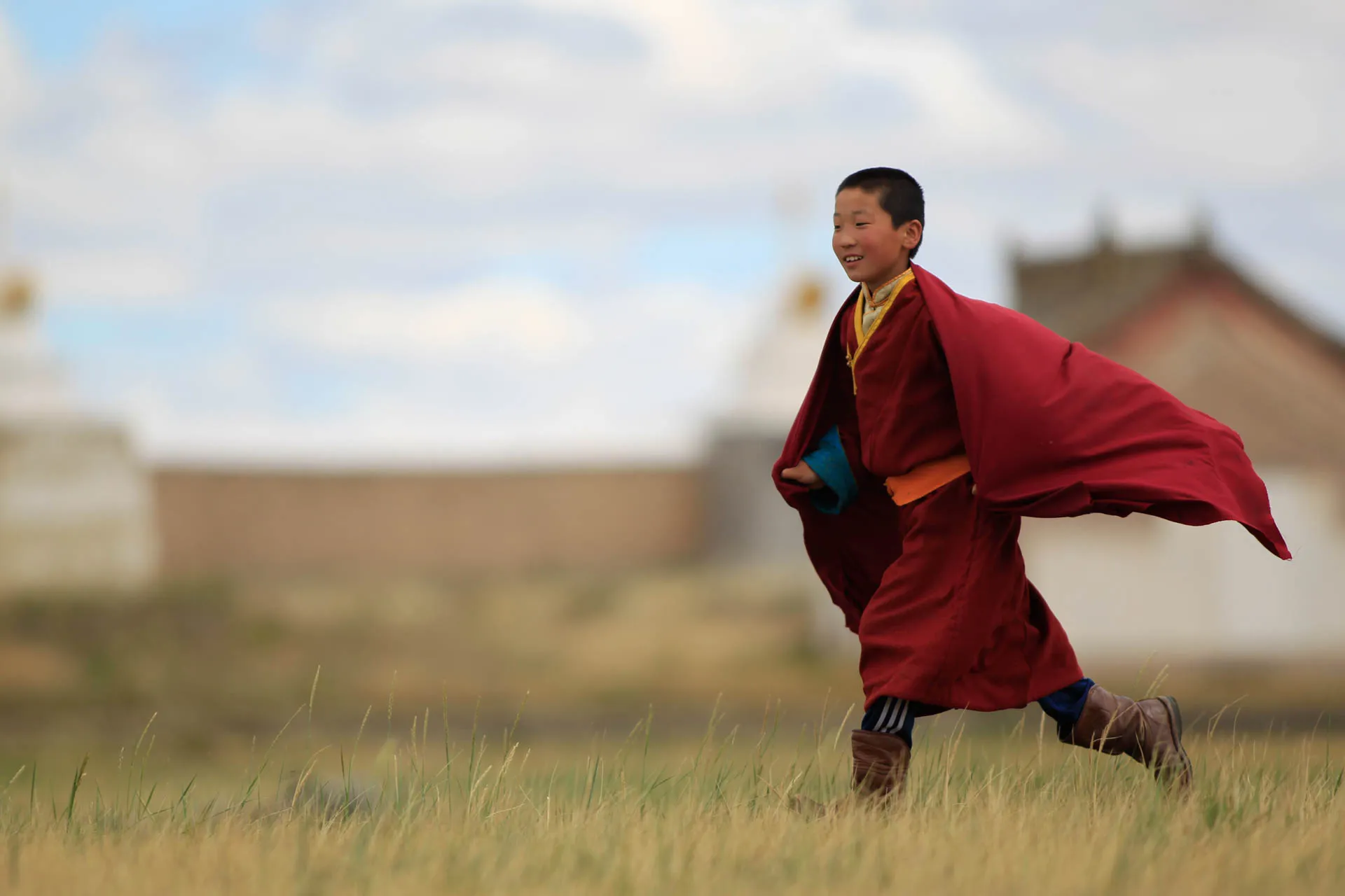 Nuori buddhalaismunkki Mongoliassa perinteisessä punaisessa kaavussa Nuori buddhalaismunkki Mongoliassa perinteisessä punaisessa kaavussa