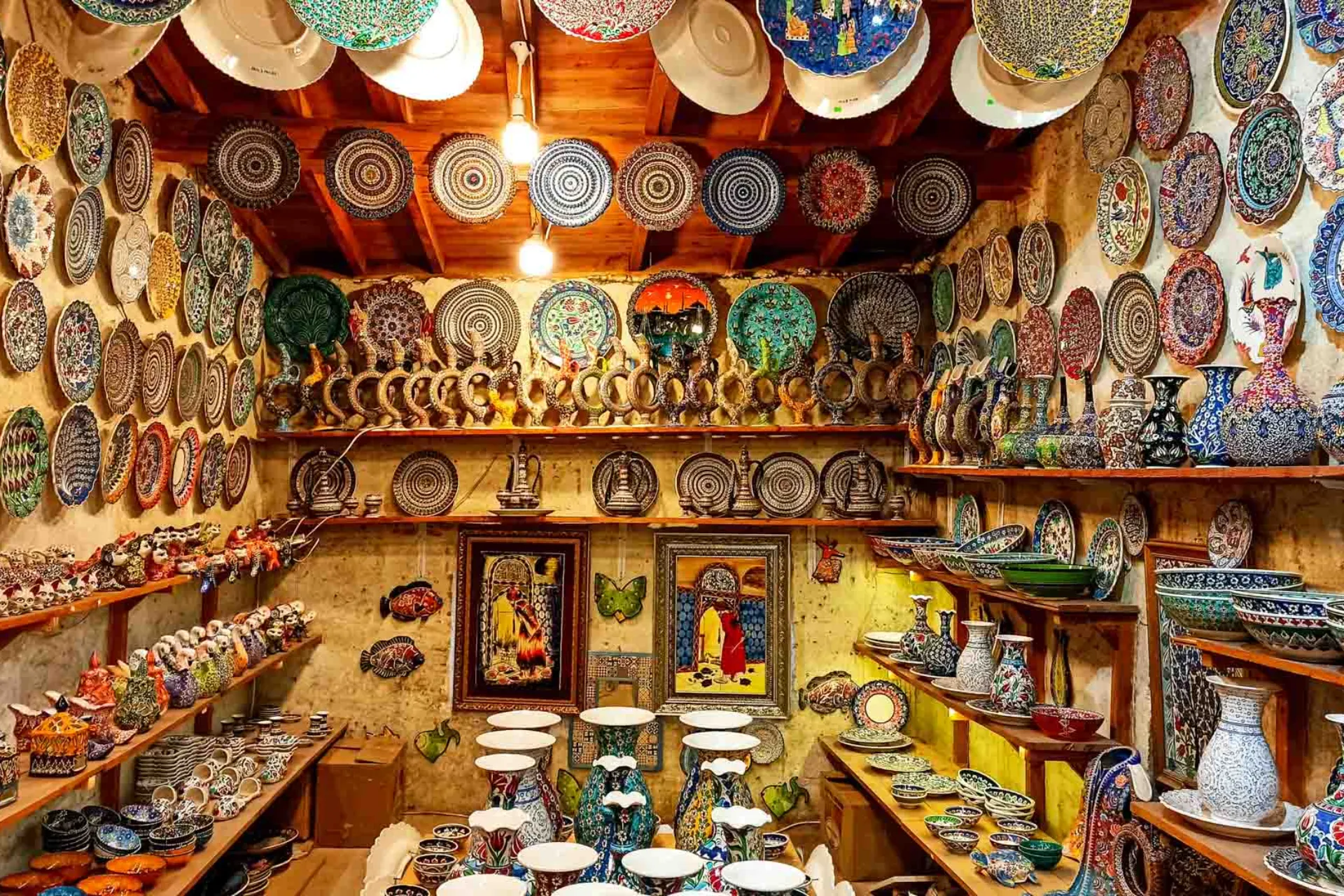 Kauppa, jossa on värikkäitä, käsinmaalattuja keramiikkalautasia, kulhoja ja maljakoita kodikkaassa, rustiikkisessa tunnelmassa Kauppa, jossa on värikkäitä, käsinmaalattuja keramiikkalautasia, kulhoja ja maljakoita kodikkaassa, rustiikkisessa tunnelmassa