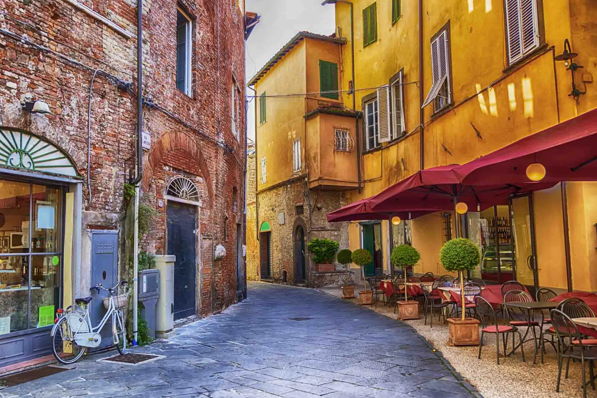 Viehättävä katu Luccassa kahviloineen ja värikkäine taloineen Viehättävä katu Luccassa kahviloineen ja värikkäine taloineen