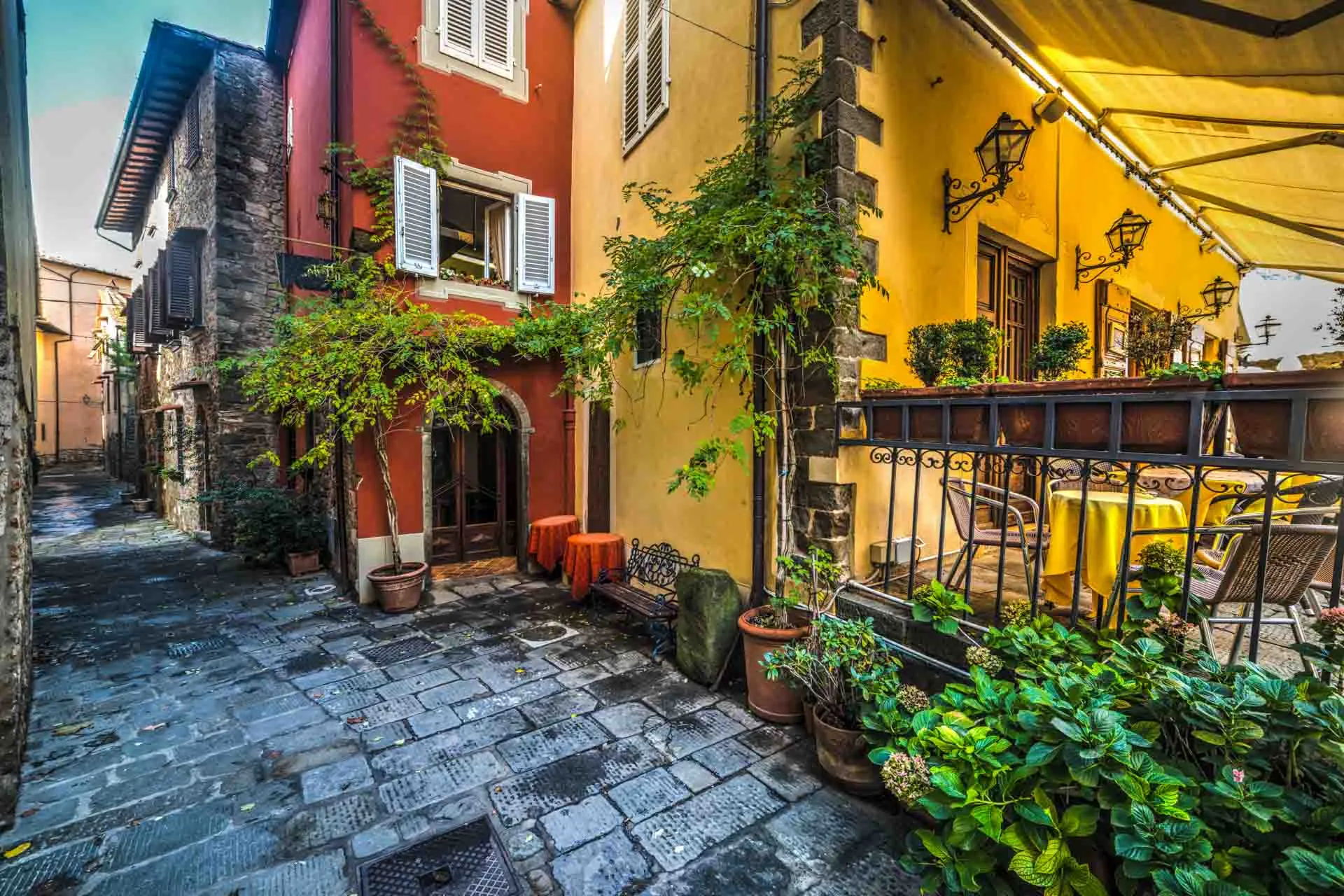 Viehättävä kuja Montecatini Altossa värikkäine taloineen ja kasveineen Viehättävä kuja Montecatini Altossa värikkäine taloineen ja kasveineen