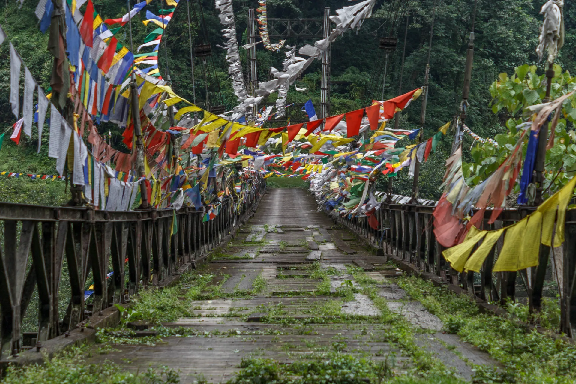 Riippusilta värikkäillä rukouslipuilla - näyttää hieman kuluneelta