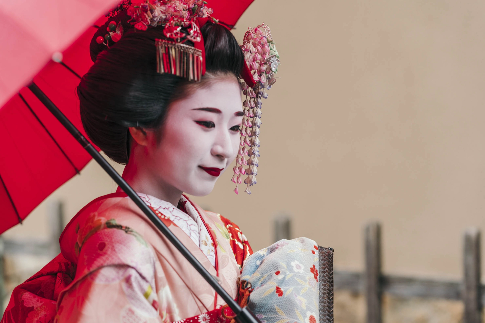 Kaunis maiko (geisha-harjoittelija) perinteisessä kimonossa ja päivänvarjon kanssa