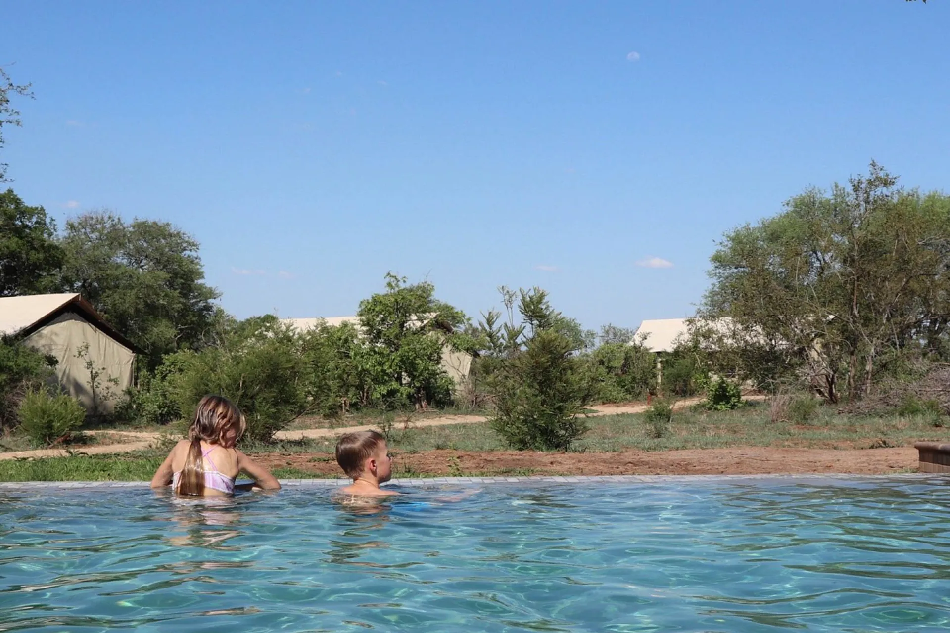 Lapset nauttivat uima-altaasta Lapset nauttivat uima-altaasta