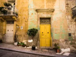 Viehättävä julkisivu, jossa on keltainen ovi Vittoriosassa – esimerkki Maltan värikkäästä kaupunkiympäristöstä