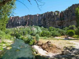 Joki vehreässä Ihlara-laaksossa, taustalla jyrkät kallioseinämät ja sininen taivas Joki vehreässä Ihlara-laaksossa, taustalla jyrkät kallioseinämät ja sininen taivas