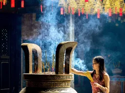 Nainen suitsuketikkujen kanssa Thien Haun temppelissä Nainen suitsuketikkujen kanssa Thien Haun temppelissä