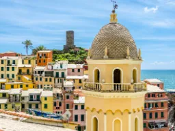 Vernazzan kirkontorni värikkäiden talojen ja merinäköalan kera Vernazzan kirkontorni värikkäiden talojen ja merinäköalan kera