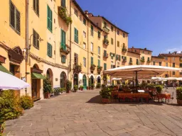 Piazza dell’Anfiteatro -aukio kahviloineen ja keltaisine taloineen Piazza dell’Anfiteatro -aukio kahviloineen ja keltaisine taloineen