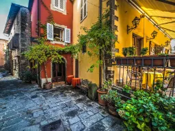 Viehättävä kuja Montecatini Altossa värikkäine taloineen ja kasveineen Viehättävä kuja Montecatini Altossa värikkäine taloineen ja kasveineen