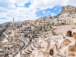 Uchisar-linna Kappadokiassa kohoaa kaupungin yläpuolelle, ympärillä taloja ja luolia pehmeään kallioon hakattuna Uchisar-linna Kappadokiassa kohoaa kaupungin yläpuolelle, ympärillä taloja ja luolia pehmeään kallioon hakattuna