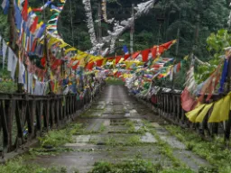 Riippusilta värikkäillä rukouslipuilla - näyttää hieman kuluneelta