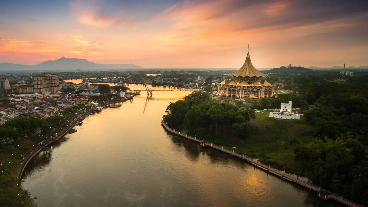 Auringonlasku Sarawakjoen yllä Kuchingissa kaupungin maamerkkien kera Auringonlasku Sarawakjoen yllä Kuchingissa kaupungin maamerkkien kera