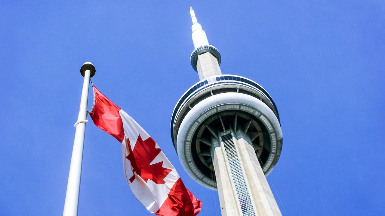Kanadan kansallislippu Maple Leaf liehuu 553 metriä korkean CN Towerin edessä Torontossa Kanadan kansallislippu Maple Leaf liehuu 553 metriä korkean CN Towerin edessä Torontossa