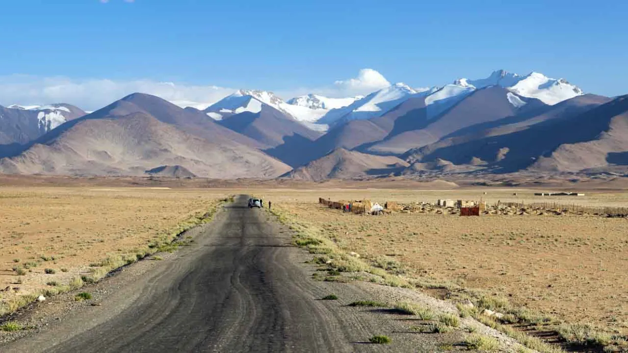 Autio ja karu osuus kuuluisalla Pamir Highwaylla, Tadžikistanin lumihuippuiset vuoret taustalla Autio ja karu osuus kuuluisalla Pamir Highwaylla, Tadžikistanin lumihuippuiset vuoret taustalla