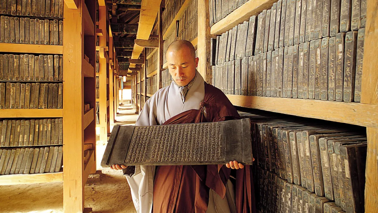 Buddhalainen munkki tutkii vanhoja puulaattoja, joihin on kaiverrettu buddhalaisia kirjoituksia Buddhalainen munkki tutkii vanhoja puulaattoja, joihin on kaiverrettu buddhalaisia kirjoituksia