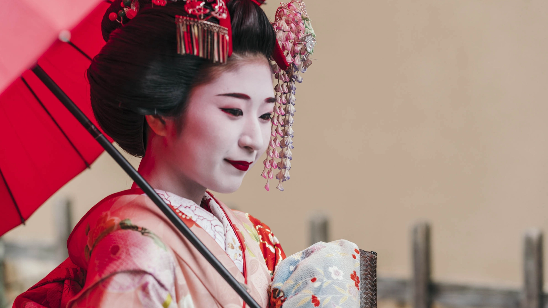 Kaunis maiko (geisha-harjoittelija) perinteisessä kimonossa ja päivänvarjon kanssa